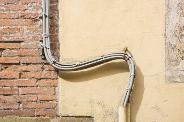 Elektrik ve telefon kabloları duvarın etrafını sarmış.