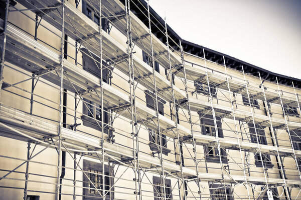 Metal scaffolding on a construction site built with prefabricated components to work safely on the facade of a building for the renovation of the plaster wall 