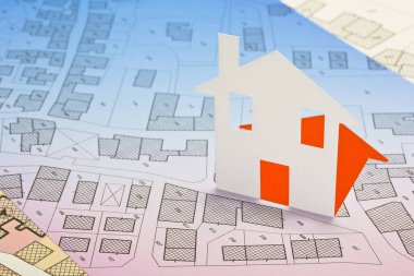 Karton ev ve hayali kadastro haritasıyla emlak kavramı, binalar, arazi paketleri ve kentsel varış noktaları göstergeleriyle Genel Şehir Planı