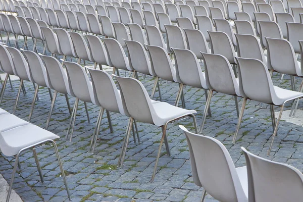 Outdoor cinema with gray plastic chairs in a row.