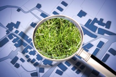 Şehir içinde yeşil bir alan aranıyor. Konsept görüntü büyüteçle görülüyor..