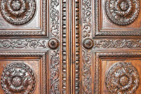Detail of an old italian wooden carved door with floral decorations - Cathedral of St. Martin (Italy-Tuscany-Lucca city)