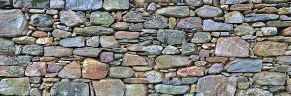 Old traditional aged and cracked stone wall made with large stone blocks