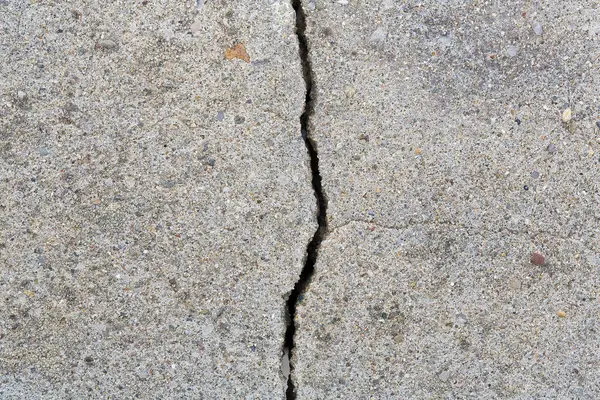 stock image Deep crack in an old brick wall with damaged plaster 