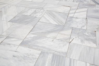 Beyaz mermer taş bloklardan yapılmış eski ve çatlak kaldırımlar. 