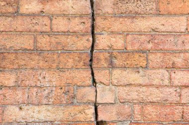 Yapısal temel çöküşü, toprak sübvansiyonu, deprem, aşınma ve yapı malzemelerinin bozulması nedeniyle tehlikeli eski çatlak tuğla duvar,