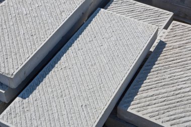 Kentsel bir şantiyede yeni bir kaldırıma monte edilmeye hazır yeni kumtaşı levhaların ahşap paleti