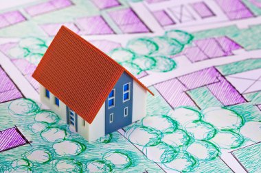 Yerel park ve yeşil alanları olan hayali kadastro bölge haritasında ev modeli ile emlak kavramı