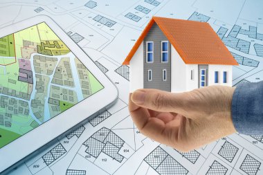 Buildings Permit concept with digital tablet, imaginary cadastral and residential building project - Building activity and construction industry with General Urban Plan and home model.	