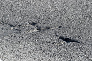 Motorlu taşıtların geçişi için tehlikeli çukurları olan tehlikeli asfalt yolu..