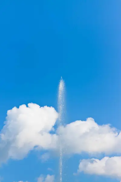 stock image Water jet of a modern fountain against a cloudy sky - Freshness concept image with copy space.