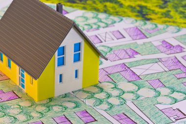 Yerel park ve yeşil alanları olan hayali kadastro bölge haritasında ev modeli ile emlak kavramı