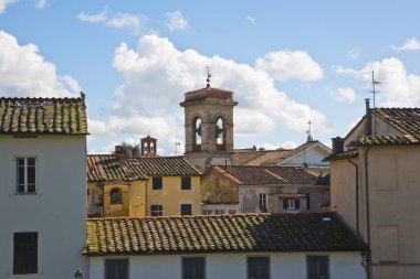 Lucca şehrinin tarihi ufuk çizgisi, arka planda eski apartman evleri ve kilise tarihi duvarların üzerinde yürüdüğü görülebilen manzara.) 