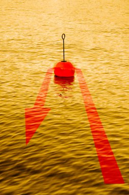 At the turning point - concept image with a red bouy on a calm golden lake and red arrow that comes back. clipart