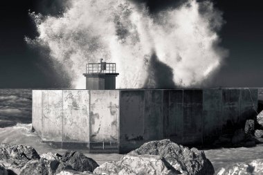 Italian lighthouse with waves and splashes of water at the port entrance (Italy-Tuscany-Pisa City-Marina Location) clipart