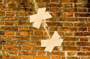 RENOVATION OF AN OLD CRACKED EXPOSED BRICK WALL - Concept with adhesive tape clipart