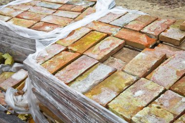 İnşaat sektöründe eski duvar ve binaların restorasyonunda kullanılan ahşap paletin üzerindeki eski tuğlalar.