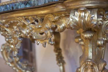 Antika altın bir ahşap İtalyan mobilyasının ayrıntıları çiçek süslemeleri ile restore edildi..