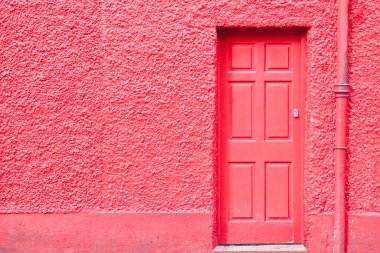 Eski boyanmış ahşap kapılı kırmızı kapı kaba alçı bir duvara karşı - kopya alanı olan resim