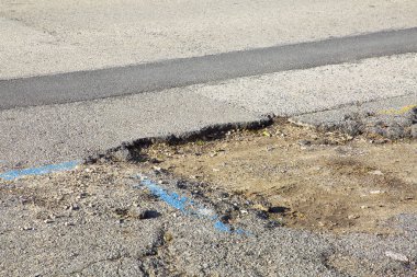 Çukur çukurları araçların geçişi için tehlikeli olan tehlikeli asfaltlı eski kırık ASPHALT Yolu