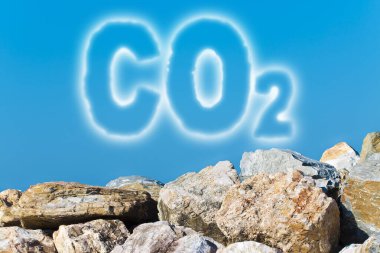 CO2 karbondioksit emisyonlarına karşı koruma - gökyüzü arka planındaki bir kaya duvarına karşı konsept