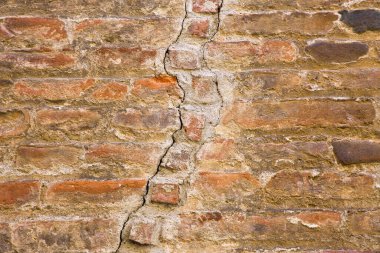Tuğla parçalarıyla dolu eski BRICK WALL Yapısal arıza, yeraltı veya depremden kaynaklanan hasar nedeniyle çatlak 