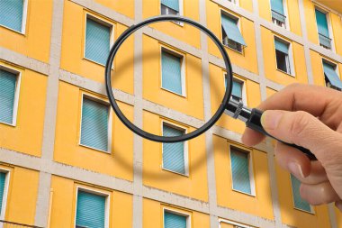 Apartman ya da apartman dairesinin yapısını kontrol etmek - Apartman duvarları ve pencereleri sıvanmış bir apartman dairesinin ön cephesine karşı büyüteç ile kavram
