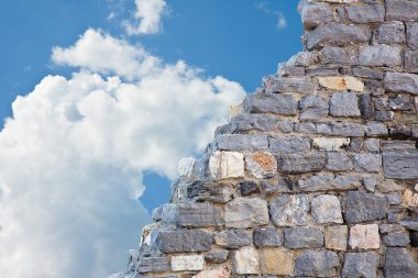 Gökyüzü zeminine karşı büyük taş blokları olan taş duvar - kopyalama alanı olan konsept resim