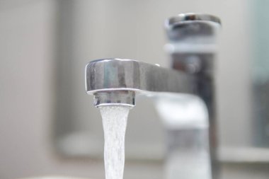 Su musluğu, musluk. Lavabolu banyoda akan su