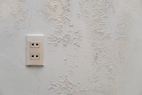 electric plugs with old white wall with mold texture background. messy wall stucco texture