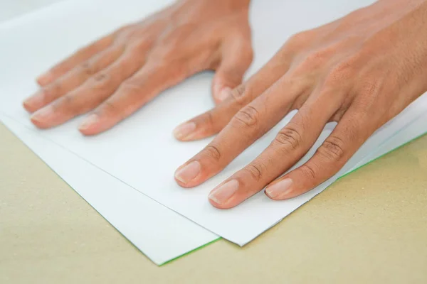 hands with white paper. folds a sheet of white paper. A writing blank. A white piece of paper