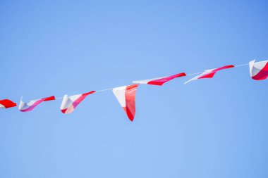 Kırmızı ve beyaz süslemeler, Endonezya 'nın Bağımsızlık Günü' nü kutlamak için mavi gökyüzünün arka planında asılı..