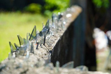 Kırık Cam Şişeler Tırmanma Karşıtı Çitler, Üst Tuğla Duvardaki Keskin Parçalar Özel Bölgeyi Korumak İçin, Ucuz Bina Güvenliği. seçici odak