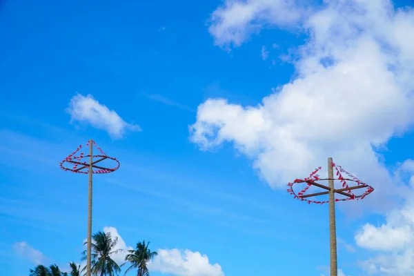 Traditional game from Indonesia named Panjat Pinang. This game won prizes that were mounted on top of the areca tree by climbing. blue sky, cloud and sun. with copy space