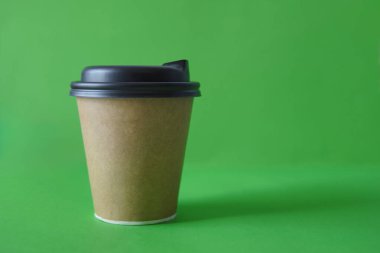 Yeşil arka planda tek kullanımlık bir fincana koymak için kahve, mesaj atabilirsin, kraft kağıt bardak. Paket kahve fincanı.