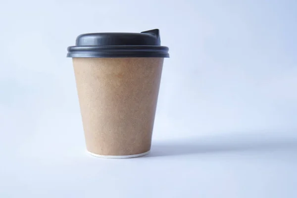 coffee to go in a disposable cup on a white background, you can place text, kraft paper cup. Takeaway paper coffee cup