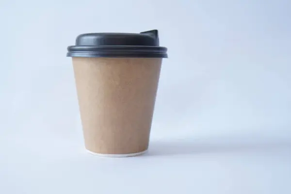 coffee to go in a disposable cup on a white background, you can place text, kraft paper cup. Takeaway paper coffee cup