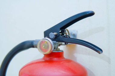 Kırmızı yangın söndürücü duvara monte edildi.