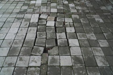 Çukurlu asfalt yol. Kötü yol. Yaya yolunda kırık asfalt levhalar. Kötü inşaat kavramı