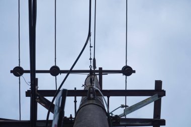 Güç iletim hatları için kullanılan uzun gri çimento direkleri. İnternet kablosu, gökyüzü arkaplanı