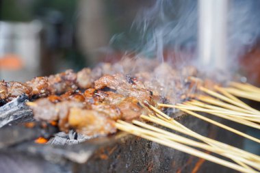 Duman ve iştah açıcı bakışlarla geleneksel kömür ateşine doydum. Izgarada satay pişirmek. Keçi satay, kuzu, et, sığır eti, ızgarada tavuk satay