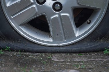 Otoparkta lastiği patlamış, tuğlalarla kaplanmış. Terk edilmiş gibi görünüyor.