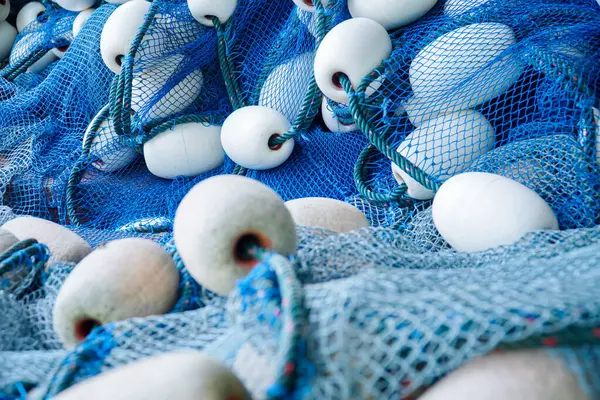 pile of blue fishing net with white floats. Trawler fishing net and floats. Fishing nets and ropes. tool for catching fish