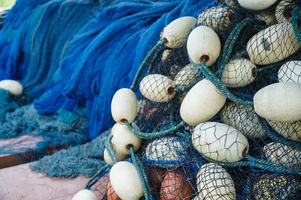 pile of blue fishing net with white floats. Trawler fishing net and floats. Fishing nets and ropes. tool for catching fish