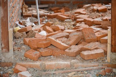 Döşemeyi söküyor, söküyor. Beton ve tuğla zemini parçalanmış. Beton yüzeyi yok ediyor. Tadilat, eski bina, inşaat. Tuğla yığını. İnşaat alanında terracotta tuğlaları.