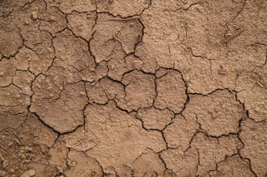 Zemin, kuraklık ve ölüm kavramına sahip arka plan veya grafik tasarımı için üst görünümde çatlaklar var..