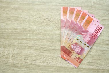 Ahşap masa arkasında yüz bin rupiah banknot. Endonezya rupiası parası. kopyalama alanı ile