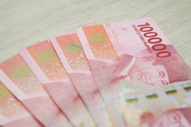 Ahşap masa arkasında yüz bin rupiah banknot. Endonezya rupiası parası. kopyalama alanı ile