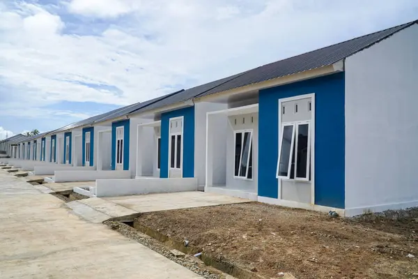 Stock image A collection of many houses neatly lined up with subsidies from the Indonesian government, which are small in size at low prices with blue sky and cloud. Row of Homes.