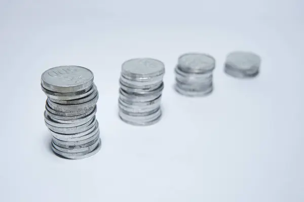 pile of silver coins stack and growing money graph on rows of 5, 10, 15, 20,coin isolated on white background with clip path. Income, profits, finance, Investment, Interest and Saving money concept.
